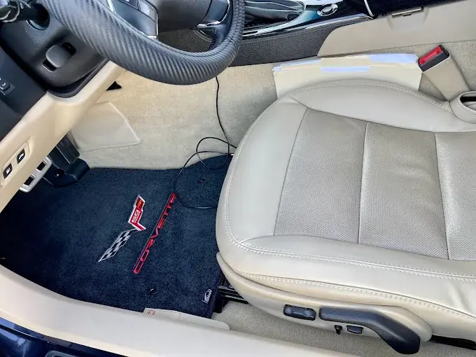 Light leather seat and carpet in a sports car interior