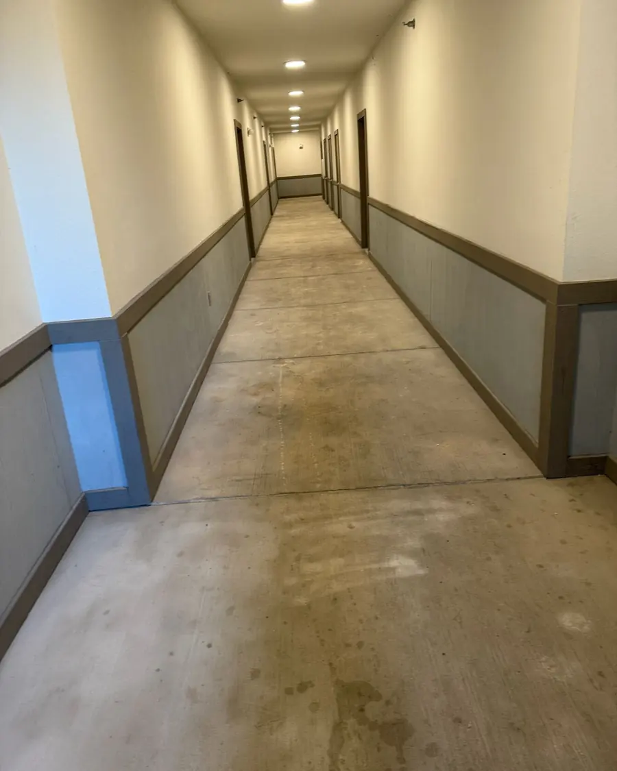 A long concrete walkway in an apartment building