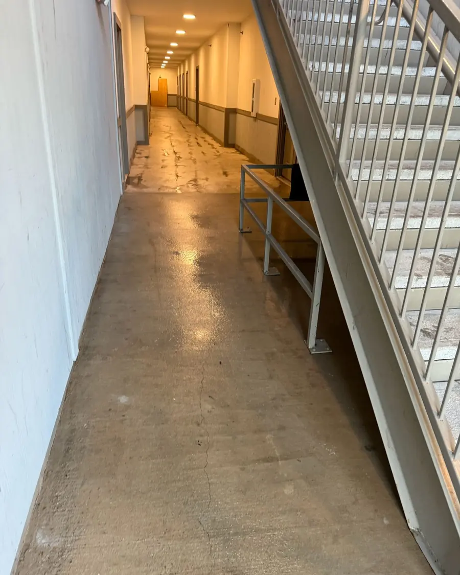 A wet concrete walkway in an apartment building