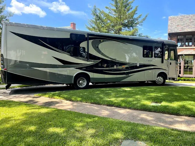 An RV parked beside a residential lawn