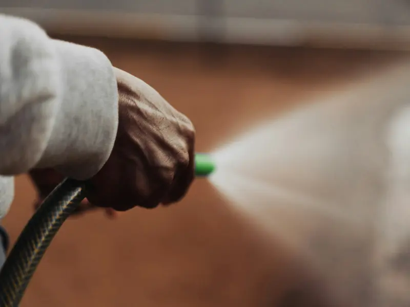 A pressure washer nozzle spraying a fan of water